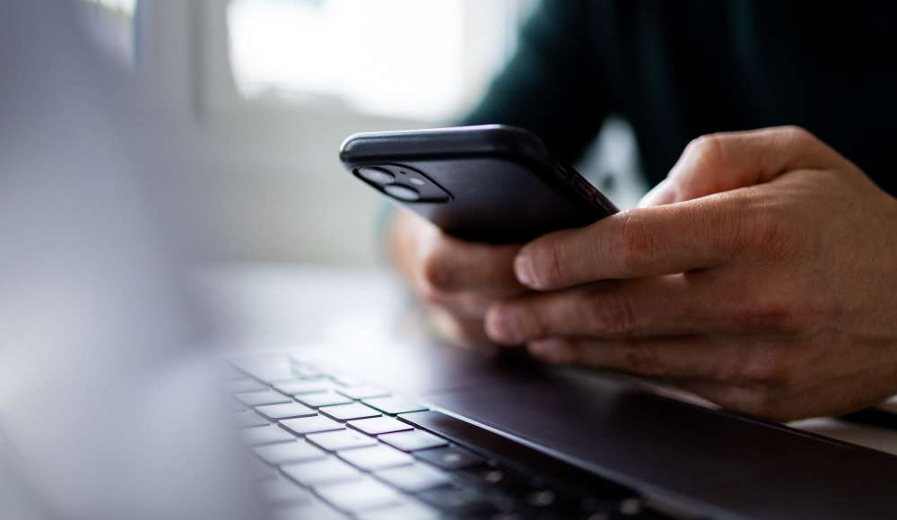 Resident using mobile at Camino Real San Antonio in San Antonio, Texas