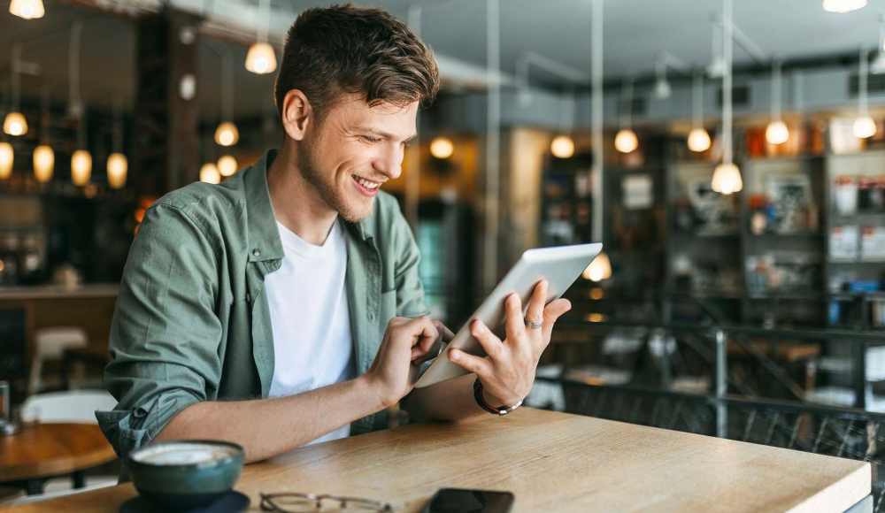 Man using tablet at coffee shop near Dunbar Apartments in Lexington, North Carolina