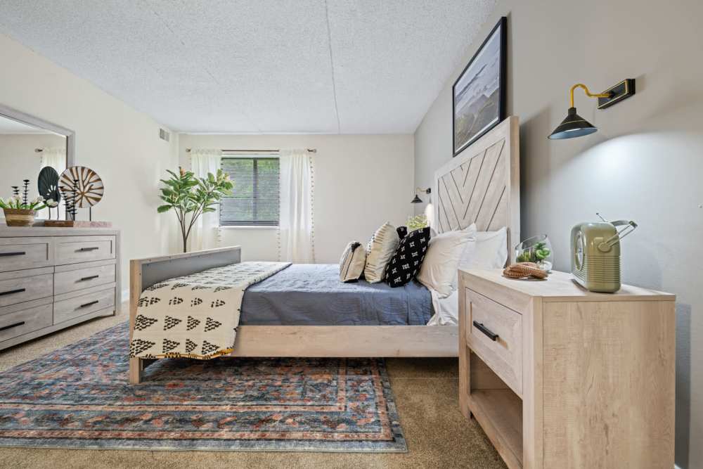 Spacious bedroom with a comfortable bed and wooden storage units at Windsor Court and Tower in Silver Spring, Maryland
