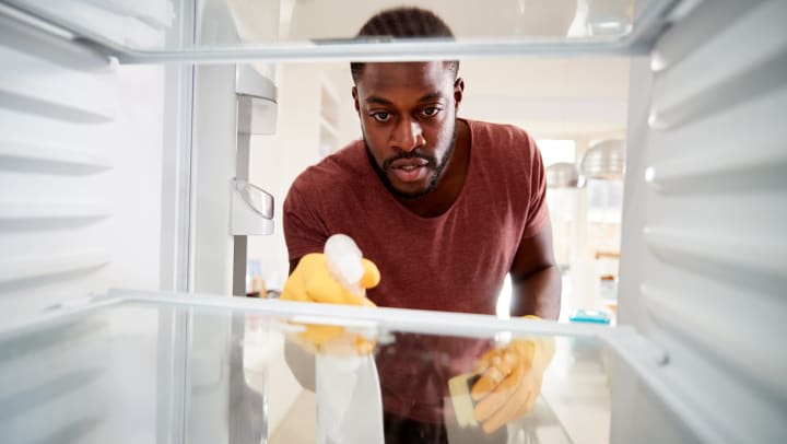 person deep cleaning their fridge | fridge cleaning tips