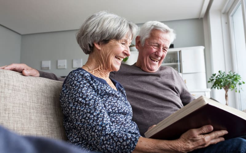 Couple looking at a photo album at Grand Villa of Clearwater in Clearwater, Florida