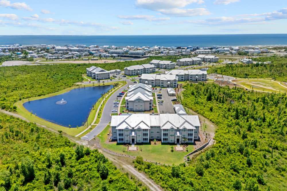 Aerial view of apartment buildings, pond, and the Gulf of Mexico.