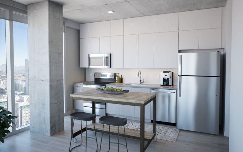 Open kitchen with white cabinetry and stainless-steel appliances in a coliving apartment at Kenect Phoenix in Phoenix, Arizona