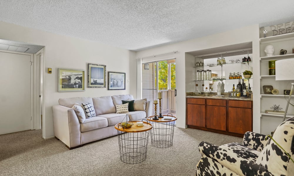 Open and bright model living room with dining table at back at The Chimneys Apartments in El Paso, Texas