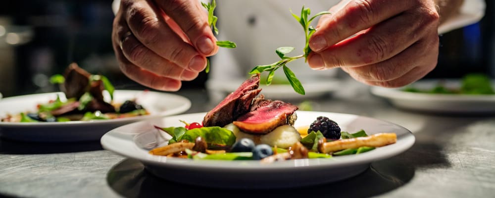Chef putting the garnish on a complete dish at The Springs at The Waterfront in Vancouver, Washington