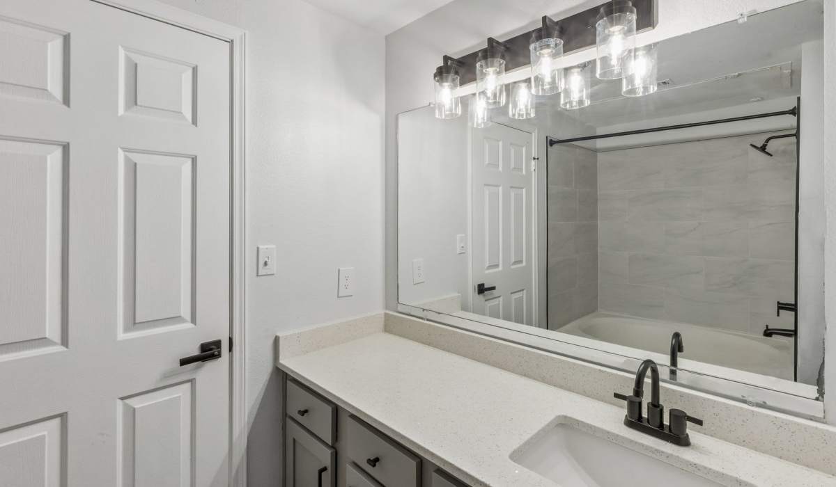 Bright bathroom with vanity light, mirror, sink and storage spaces at 530 Buckingham in Richardson,Texas