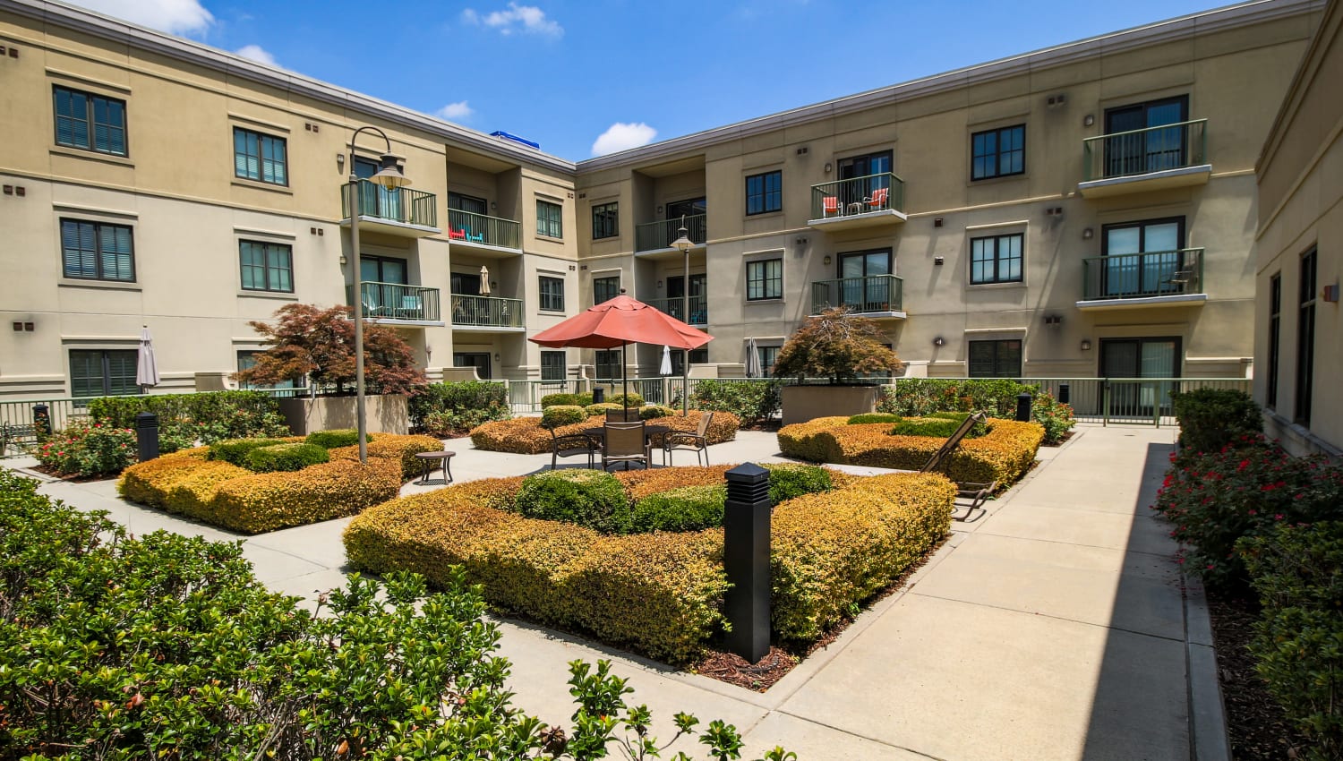 Sunny courtyard with a patio table and umbrella at SouthPark Morrison in Charlotte, North Carolina
