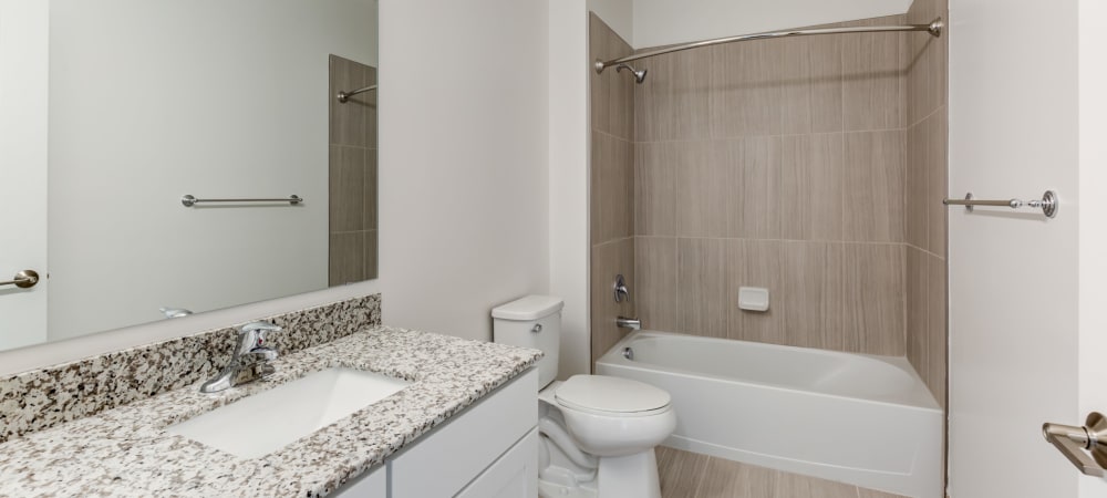 Spacious bathroom with large mirror and ample counter space at Main Street Apartments in Rockville, Maryland