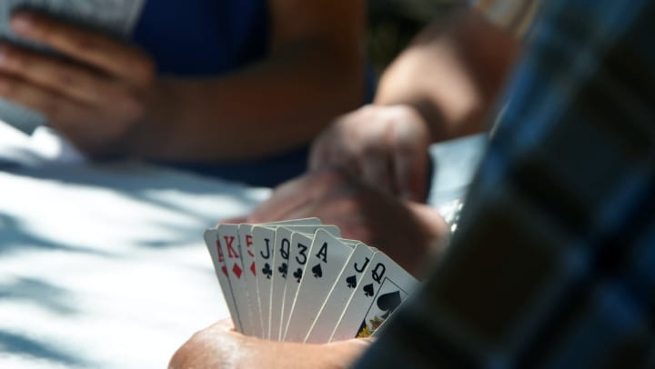 Man playing cards at {{location_name}} in {{location_city}}, {{location_state_name}}