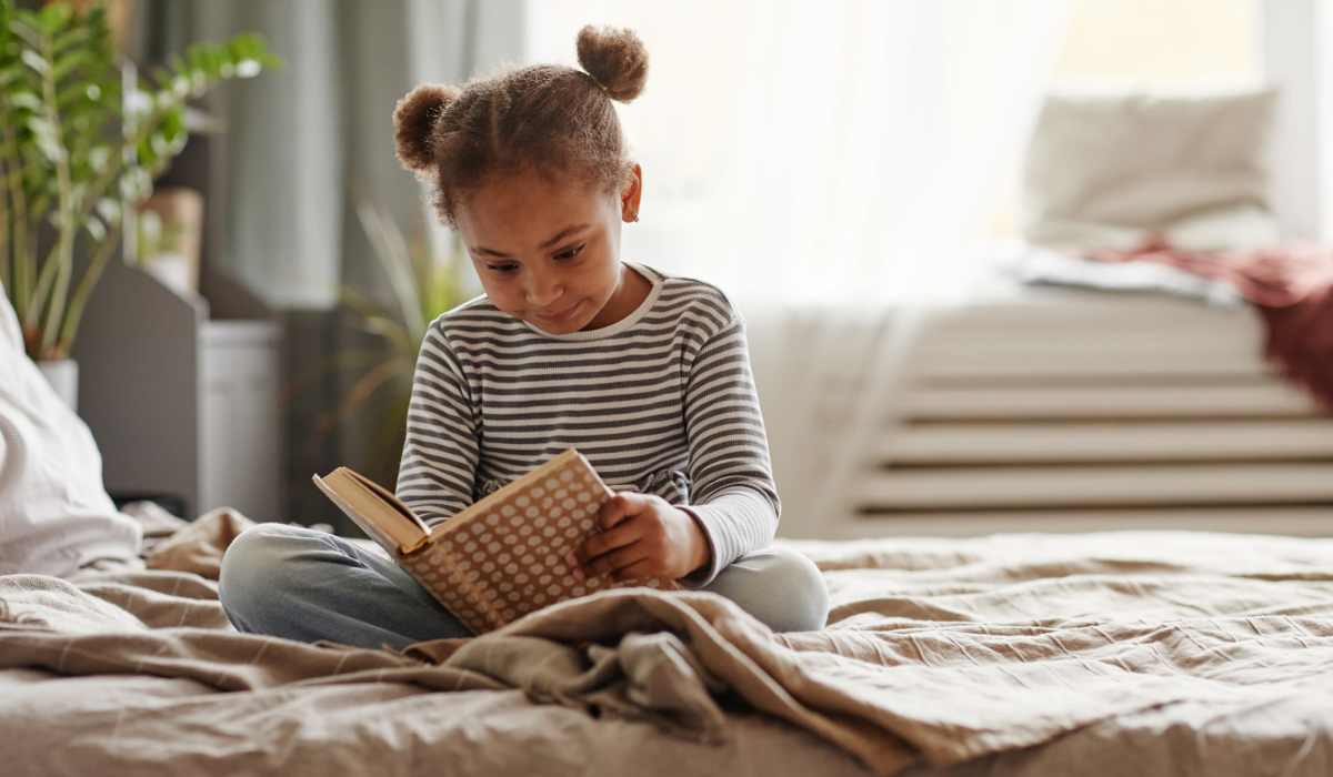 A young girl reads a book in her room at Rockwood Park, Richmond, Virginia