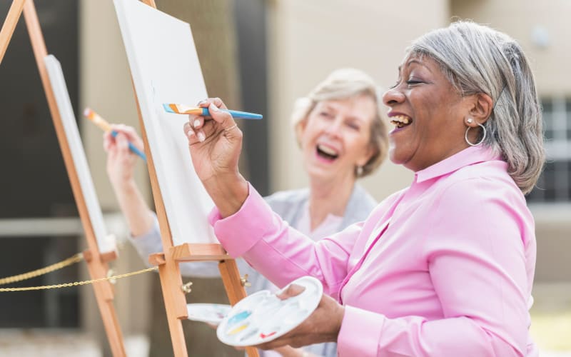 Resident laughing together while painting at Kirkwood Orange in Orange, California