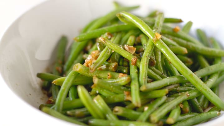 Green beans with garlic and seasoning in a bowl.