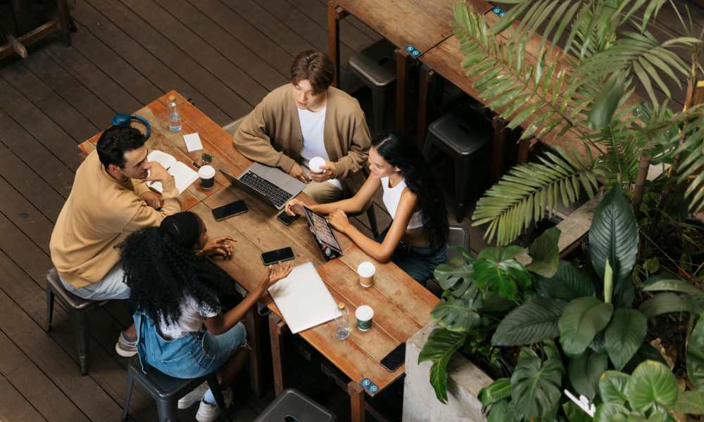 A group of students sitting at tables, focused on their work and interacting with one another at Mazza Grandmarc in College Park, Maryland