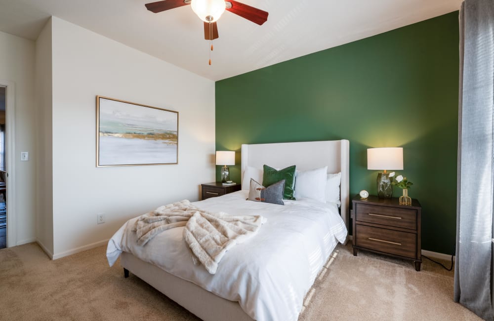 Staged bedroom with wall to wall carpeting at Easton Commons Apartments & Townhomes in Columbus, Ohio