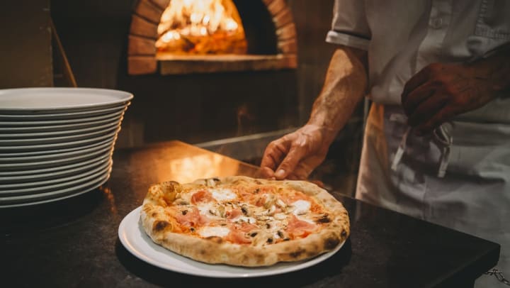 Chef preparing a wood-fired pizza at a pizzeria in Ooltewah