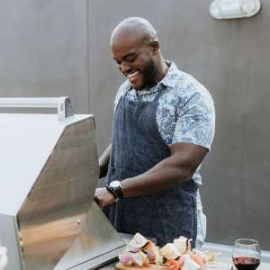 Man cooking on grill at The Grand at Bayfront in Hercules, California