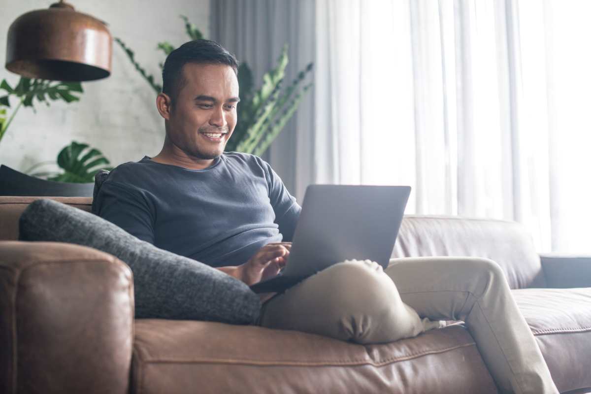 Man relaxing in the living room using his laptop at The Dartmouth North Hills in Raleigh, North Carolina