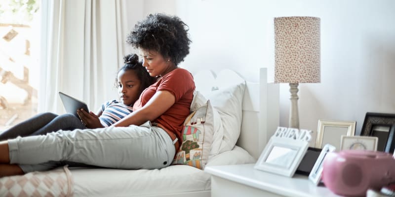 A happy mother with her kid on bed at Desert Winds in Fallon, Nevada