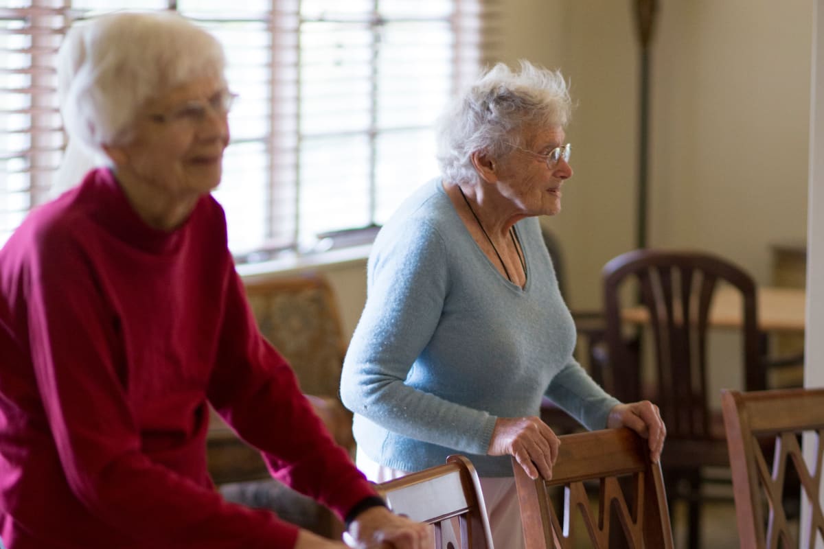 Two residents standing behind chairs at Gables of Ojai in Ojai, California