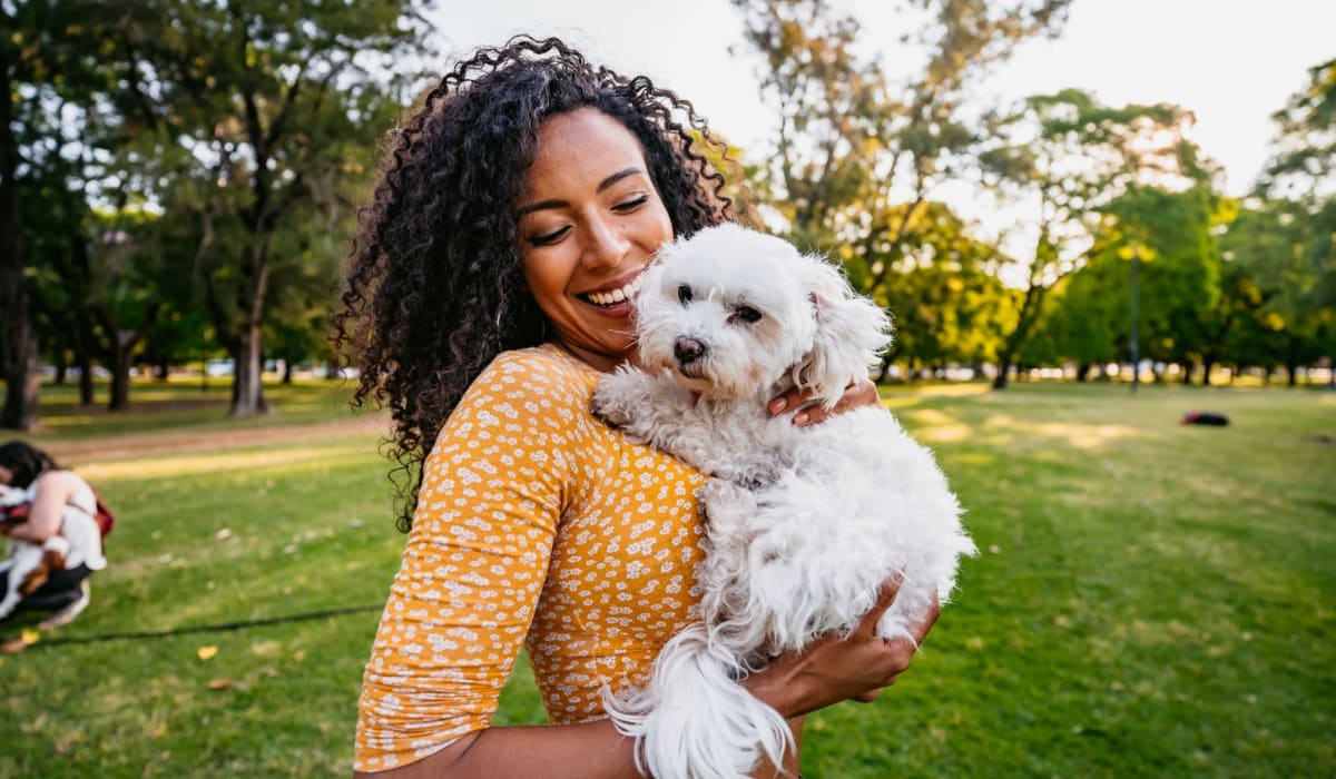 Resident holding her happy dog near The Palms Apartments in Sacramento, California