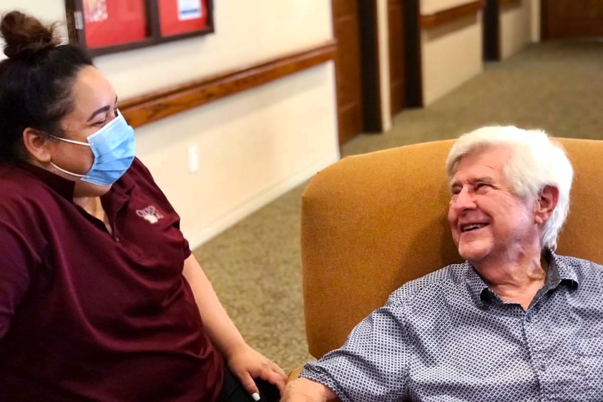 A resident talking to a masked caretaker at Oxford Senior Living in Wichita, Kansas