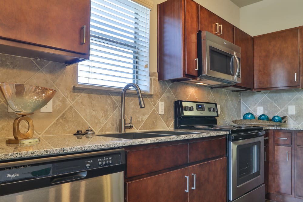 Custom wood cabinetry and stainless-steel appliances in a model home's gourmet kitchen at Olympus at Waterside Estates in Richmond, Texas