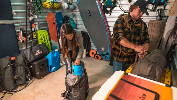 Two outdoorsy individuals accessing their storage unit