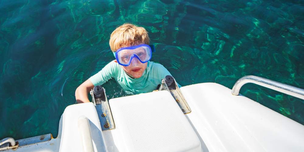 Resident kid in a boat at Springfield RV and Boat Storage in Springfield, Oregon
