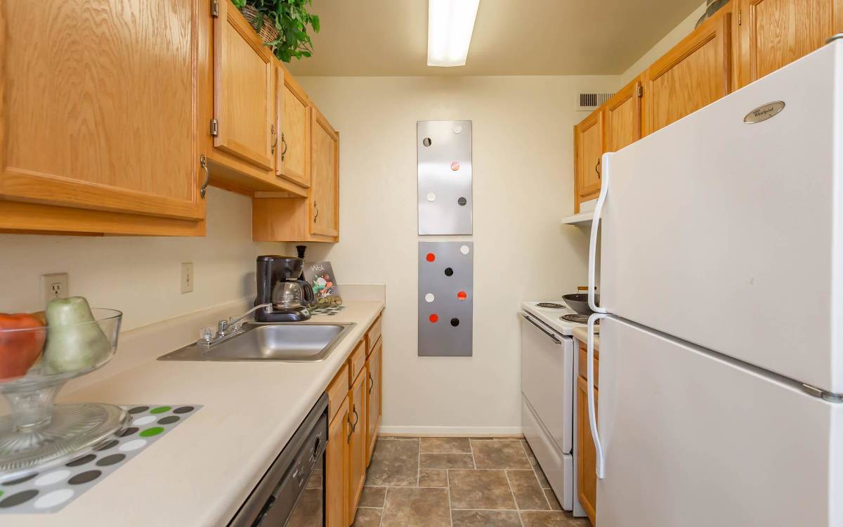 Kitchen with wooden cabinets at Village at Town Park in Hampton, Virginia