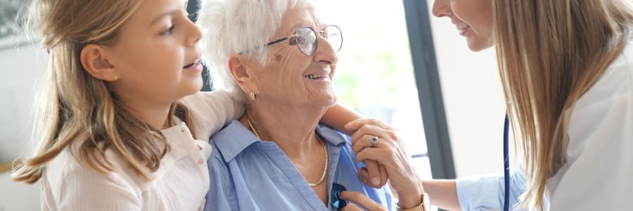 Caregiver checking a resident's heartbeat with a child at Transitions At Home - West in Mount Horeb, Wisconsin