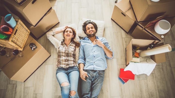 Young couple lying on the floor of a new apartment.