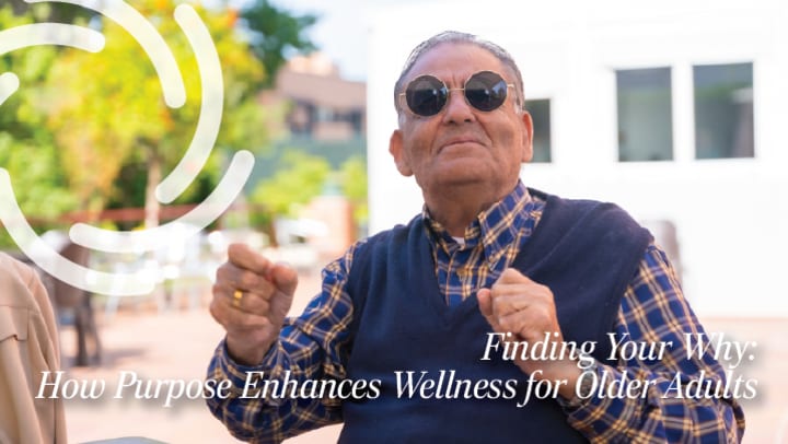 Senior man outside wearing sunglasses and a dark blue v-neck sweater