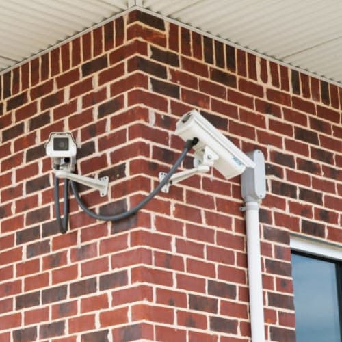 Security cameras mounted on a brick wall at Red Dot Storage in Woodstock, Illinois