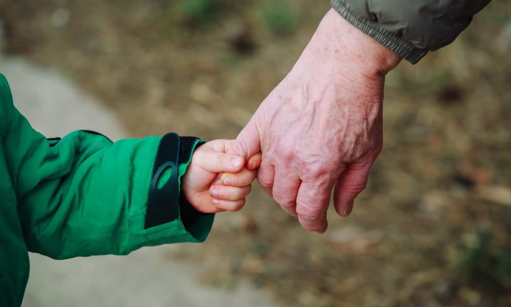 Resident and grandchild holding hands at Amaran Senior Living in Albuquerque, New Mexico. 