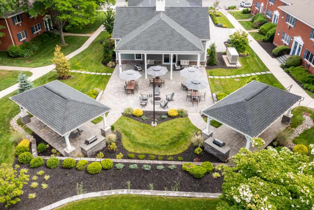Landscaped courtyard with covered pavilion, outdoor seating, umbrellas, walking paths, and surrounding residential buildings at Center Grove Village in Randolph, New Jersey.