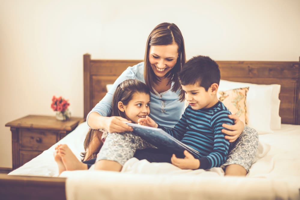 A resident reading a bedtime story to her kids at home at 29 Central at Stonefield in Charlottesville, Virginia