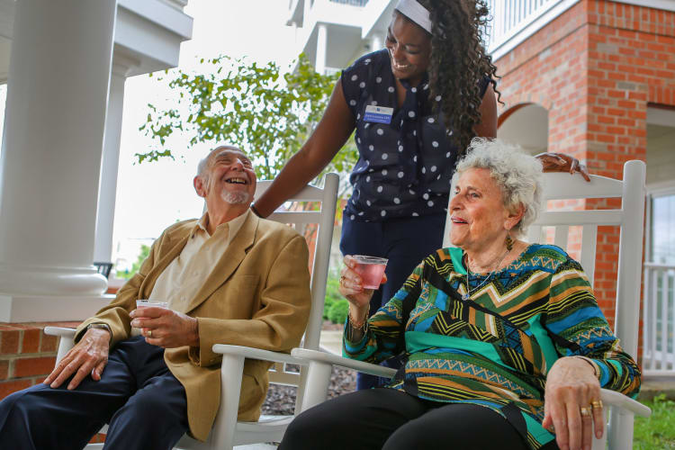 A caregiver speaking with two residents outside at Harmony Senior Services in Charleston, South Carolina