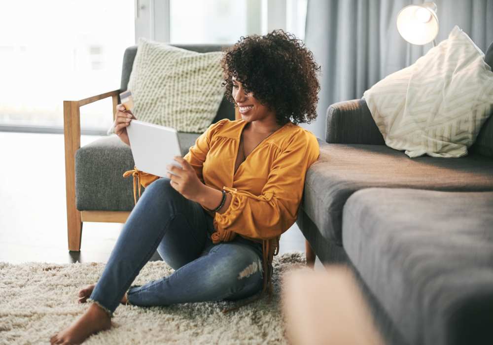 A resident woman sitting in her apartment living room at Village on Wiley in Jacksonville, Florida