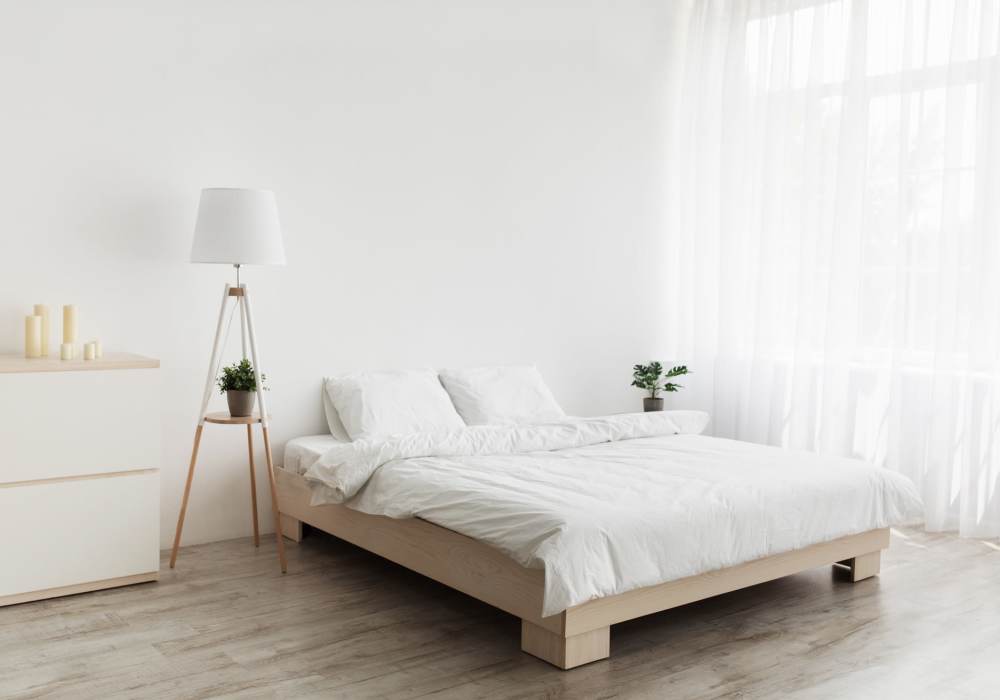 Model bedroom with wood-style flooring at Legends at North Ponds in Webster, New York