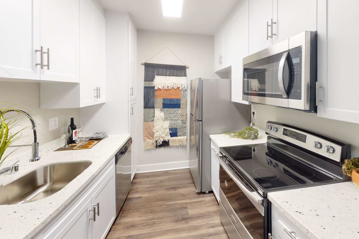 Modern kitchen with wood-style flooring at Axiom Tustin in Tustin, California