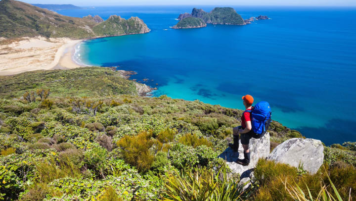 A person on top of a mountain near the ocean