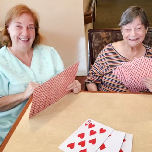 Resident friends playing cards Oxford Glen Memory Care at Grand Prairie in Grand Prairie, Texas