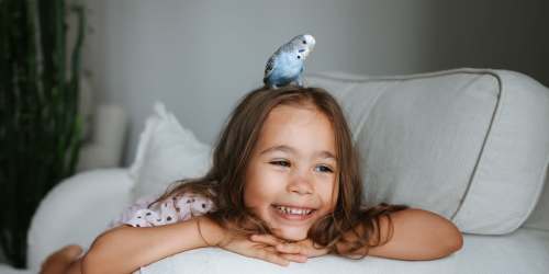 A cute little girl playing with her pet parrot at Villas At Millbrook in Fresno, California