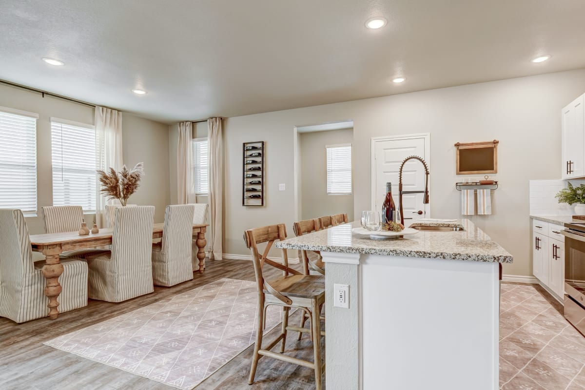 Dining area and kitchen island at BB Living Harvest in Argyle, Texas