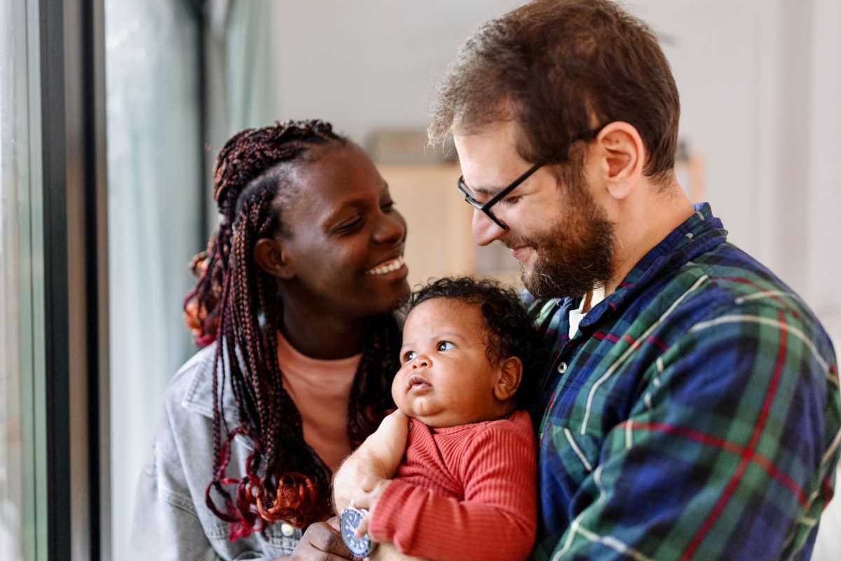 Couple with infant smiling at The Towns at Patuxent Overlook in Lexington Park, Maryland           