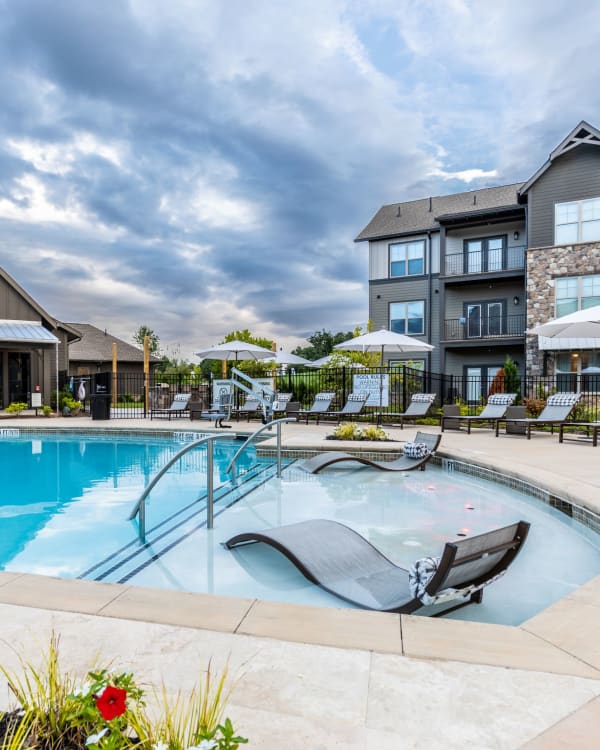Resort-style swimming pool with in-pool seating at The Holston | Apartments in Weaverville, North Carolina