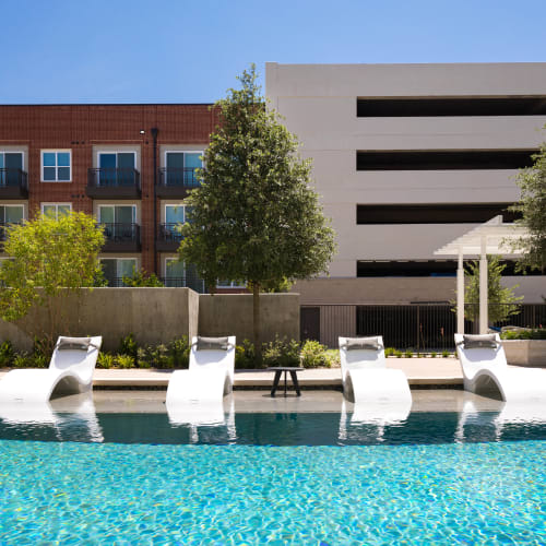 Lounge chairs on the sun deck at the swimming pool at Lux on Main in Carrollton, Texas