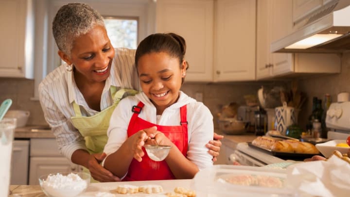 Older woman and young girl baking cookies in a kitchen