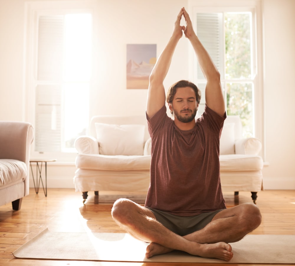 Resident doing yoga in his room at 5th Street Crossing City Center in Garland, Texas