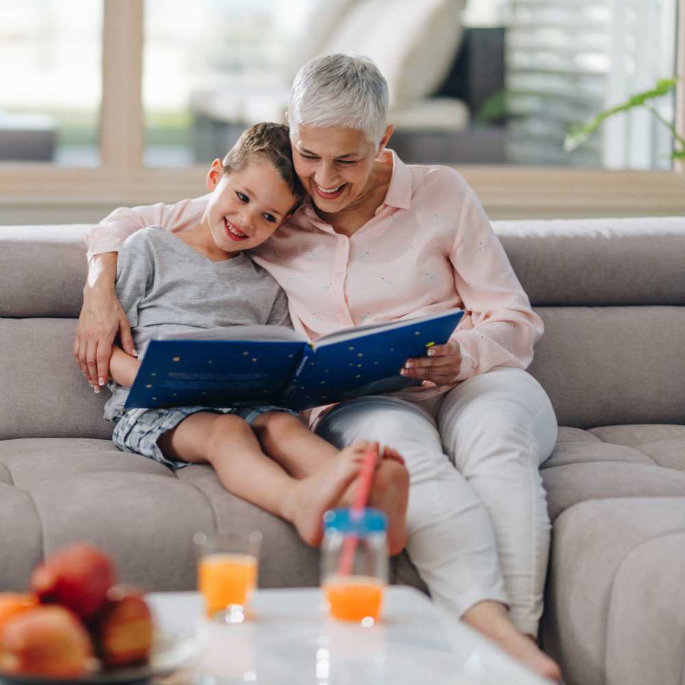 Resident with kid seating in sofa in living room at Clintonville Commons in North Haven, Connecticut